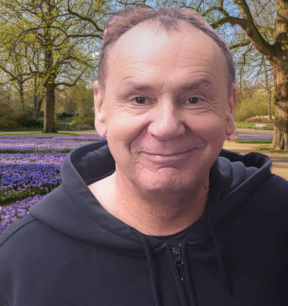 Nahaufnahme von Jacques Tilly, Düsseldorfer Großplastiken- und Karnevalswagenbauer, im Hintergrund der Hofpark zur Krokusblüte
